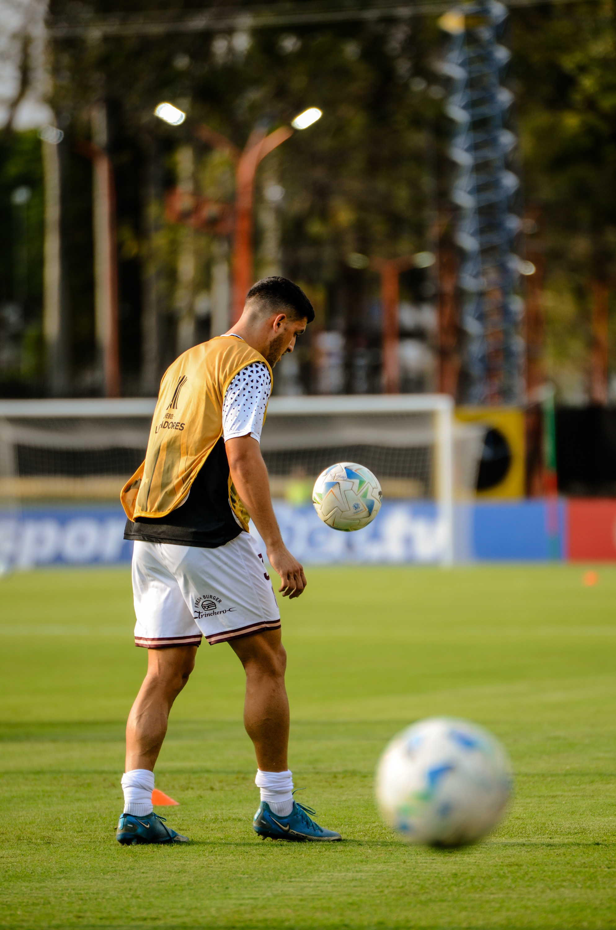 Ezequiel Neira entrena con una pechera de la Copa Libertadores, dominando la pelota en la entrada en calor.